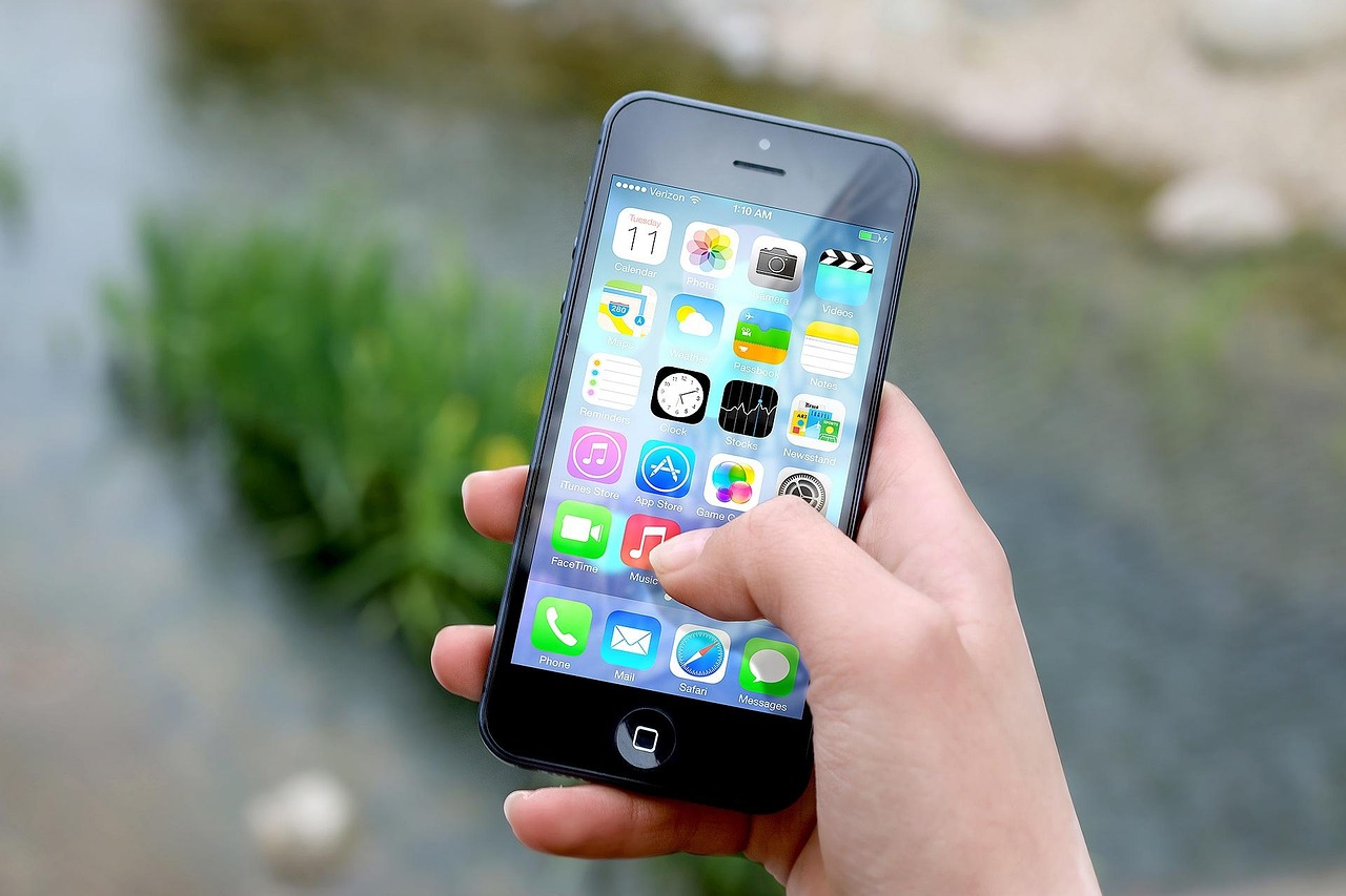 Hand holding an iPhone showing an application on screen