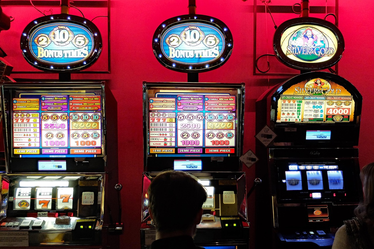 Casino slot machines glowing with colourful game symbols